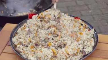 Aşçı sıcak pilavı kasede servis ediyor.