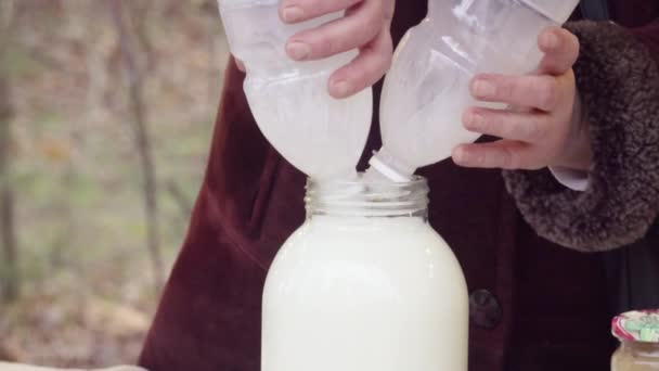 Mulher da colheita derramando leite em jarra no mercado local — Vídeo de Stock