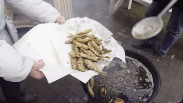 Säljare som lägger friterad fisk på brickan — Stockvideo