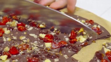 Ekin ev hanımı ev yapımı çikolata kesiyor.