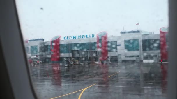 Aeroporto moderno atrás da janela de avião molhado — Vídeo de Stock