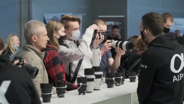 Fotógrafos em máscaras verificando lentes na loja — Vídeo de Stock