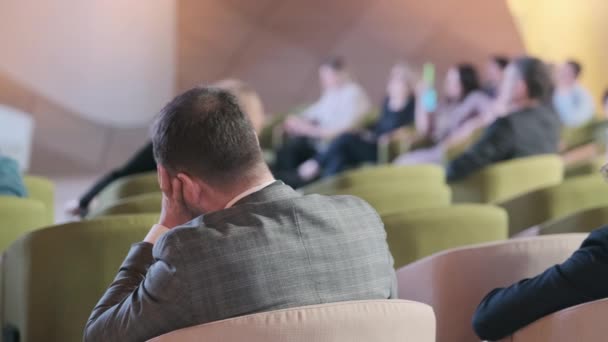 Publiek luistert naar de docent in de conferentiezaal — Stockvideo