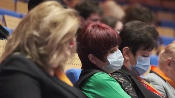Personas con máscaras protectoras en el auditorio — Vídeo de stock