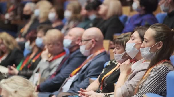 Konferans salonunda koruyucu maskeler takan insanlar — Stok video