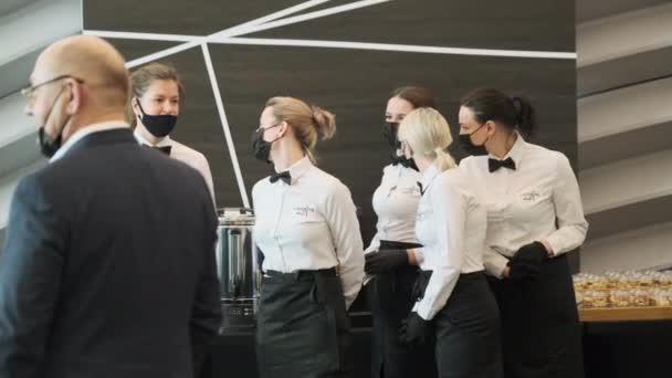 Pincérnők maszkban fogadják a konferencia vendégeit. — Stock videók
