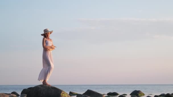 Romantic female in white dress dancing on coast — Stok Video