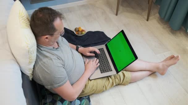 Uomo irriconoscibile che utilizza il computer portatile a casa — Video Stock