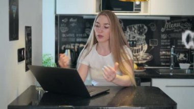 Kadın mutfakta video görüşmesi yapıyor.