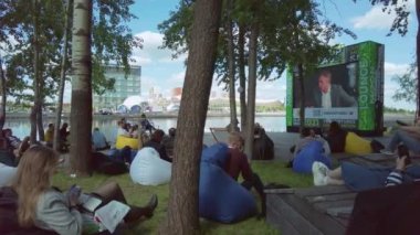 Parktaki açık hava seminerine katılan insanlar
