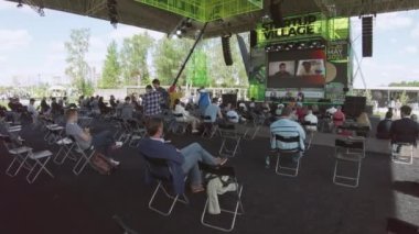 Açık hava konferansına katılanlar konuşmacıyı dinliyorlar