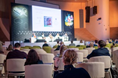 Konferans katılımcıları konferans salonunda oturuyorlar