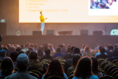 İş konferansı sırasında konuşmacıları dinleyen tanınmayan insanlar