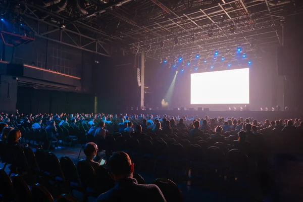 Зрители сидят перед сценой с экраном — стоковое фото