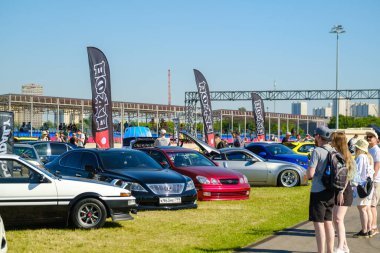 Seyirciler fuar sırasında modern arabalara bakıyor