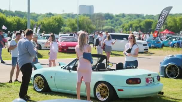Зрители смотрят на современные автомобили во время выставки — стоковое видео