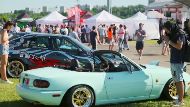 Spectators looking at modern cars during trade show — Stock Video