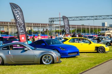 Seyirciler fuar sırasında modern arabalara bakıyor