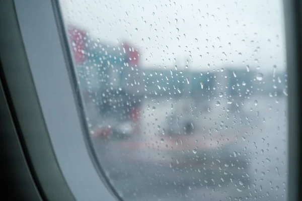 Nowoczesne lotnisko za mokrym oknem samolotu — Zdjęcie stockowe