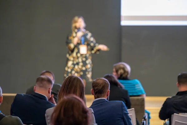 Publiek luistert naar vrouwelijke spreker in workshop — Stockfoto