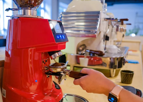 Barista malning kaffe i caféet Stockfoto