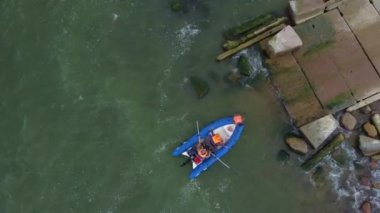 İnsanlar hasarlı rıhtıma yanaşıyor.