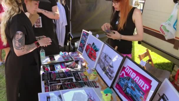 Orang-orang membeli barang dagangan terkait mobil selama festival — Stok Video