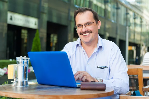 Middle age businessman works on laptop — Stock Photo, Image