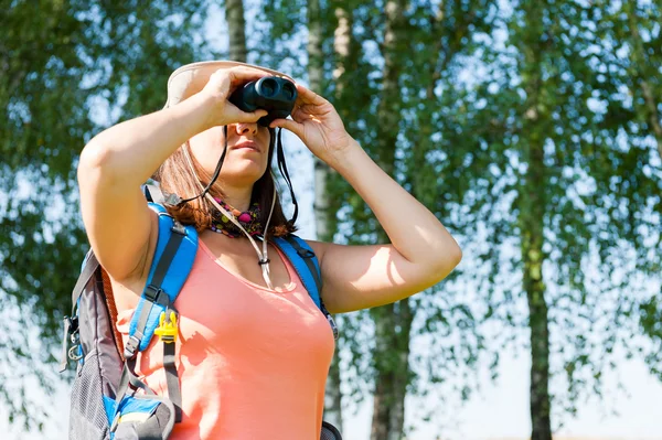 Jonge vrouw kijken door verrekijker — Stockfoto