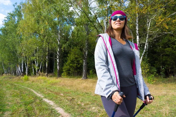 Joven mujer va nórdica caminar — Foto de Stock