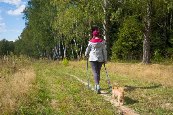Молодая женщина идет нордической ходьбой — стоковое фото