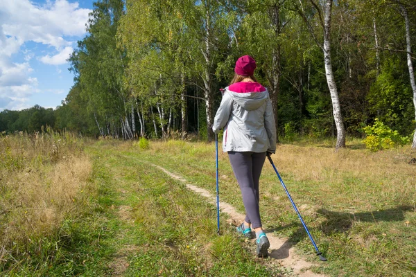Joven mujer va nórdica caminar — Foto de Stock