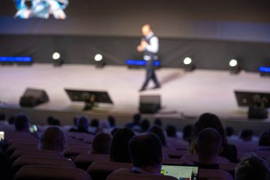 Seyirci izlerken sahne ışıkları hoparlörü aydınlatarak dinamik bir konferans atmosferi yaratıyor. 