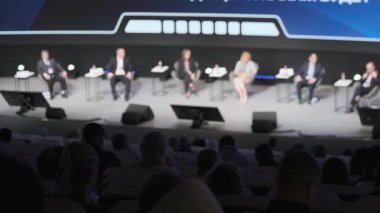 Çeşitli profesyonellerden oluşan bir panel konferansta seyircilerle iş görüşlerini tartışıyor.