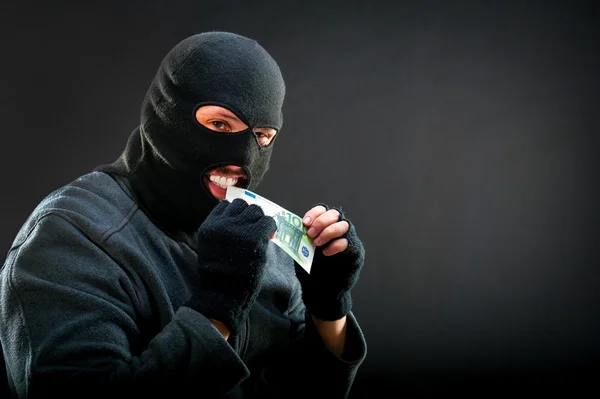 Crime man biting euro — Stock Photo, Image