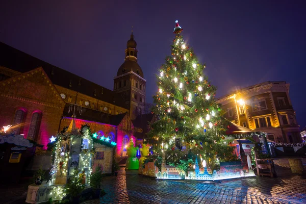Люди посещают Рождественскую ярмарку в старом городе вечером — стоковое фото