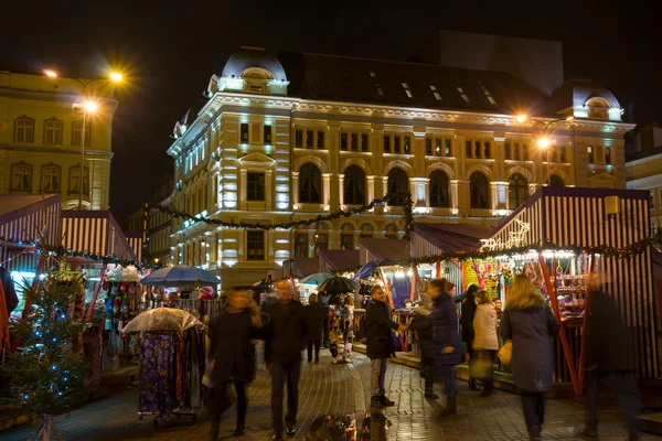 As pessoas visitam a Feira de Natal na cidade velha à noite — Fotografia de Stock
