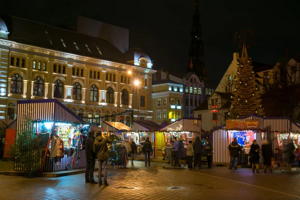 As pessoas visitam a Feira de Natal na cidade velha à noite — Fotografia de Stock
