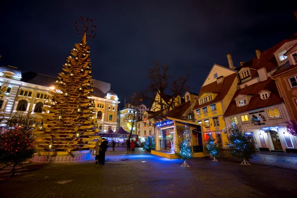 Mensen bezoeken eerlijke Kerstmis in de oude stad bij avond — Stockfoto