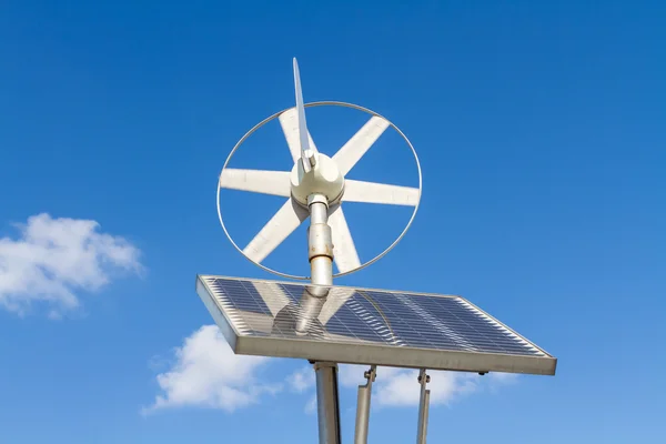 Wind and solar power system against the clear blue sky.