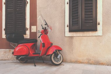 Kırmızı scooter boş sokakta duvarın Park.