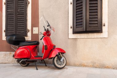 Kırmızı scooter boş sokakta duvarın Park.