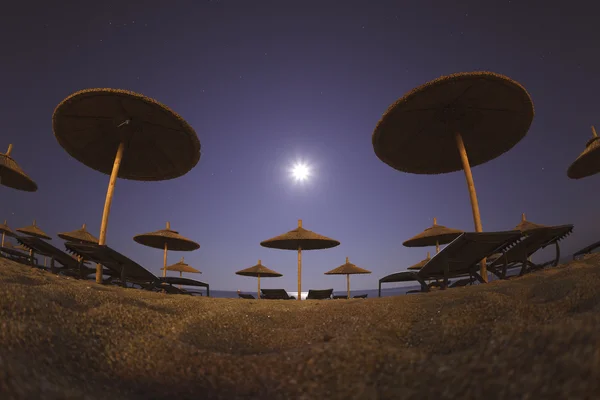 Guarda-chuvas de praia no papel de parede noturno — Fotografia de Stock