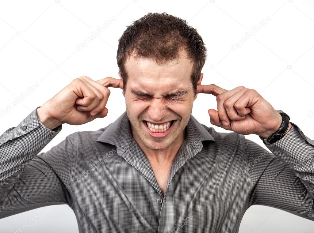 Too much noise concept - man covering ears with fingers