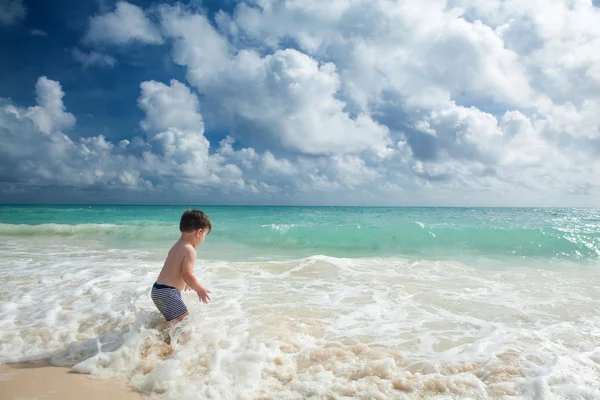 Chlapec enyojs letní den na tropické pláži. — Stock fotografie