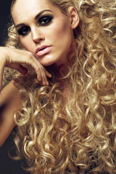 Uzun kıvırcık sarışın saçlı genç kız.