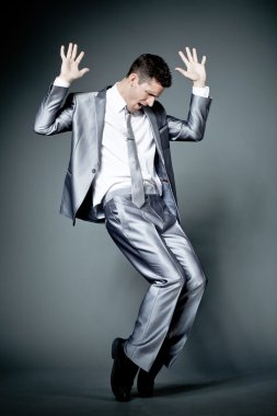 Gri takım elbiseli mutlu işadamı.