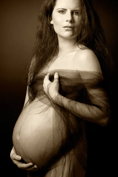 Vackra gravid kvinna med långt lockigt hår. — Stockfoto