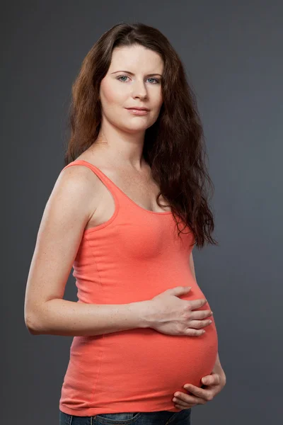 Junge werdende Mutter mit langen dunklen Haaren. — Stockfoto