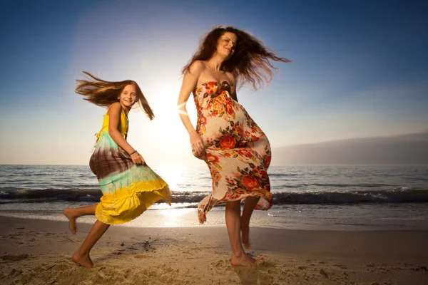 Mãe e filha dançando na bela praia . — Fotografia de Stock